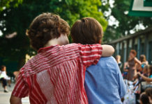 Study Links Emotional Intelligence and School Achievement two boys hugging from back