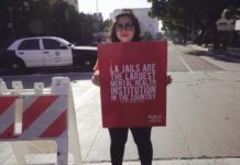 Bedlam: Public Media, Power, and the Fight for Narrative Justice A woman holding a sign that says LA Jails are the Largest Mental Health Institution in the Country."