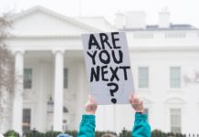 Who Is a Danger to Others: The “Mentally Ill” or the Powerful? Protester holding up sign "Are you next?" in front of the White House