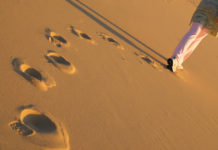 To the Young Person Who Doesn’t Identify with Their Disability Diagnosis Anymore woman walking away, footprints in the sand