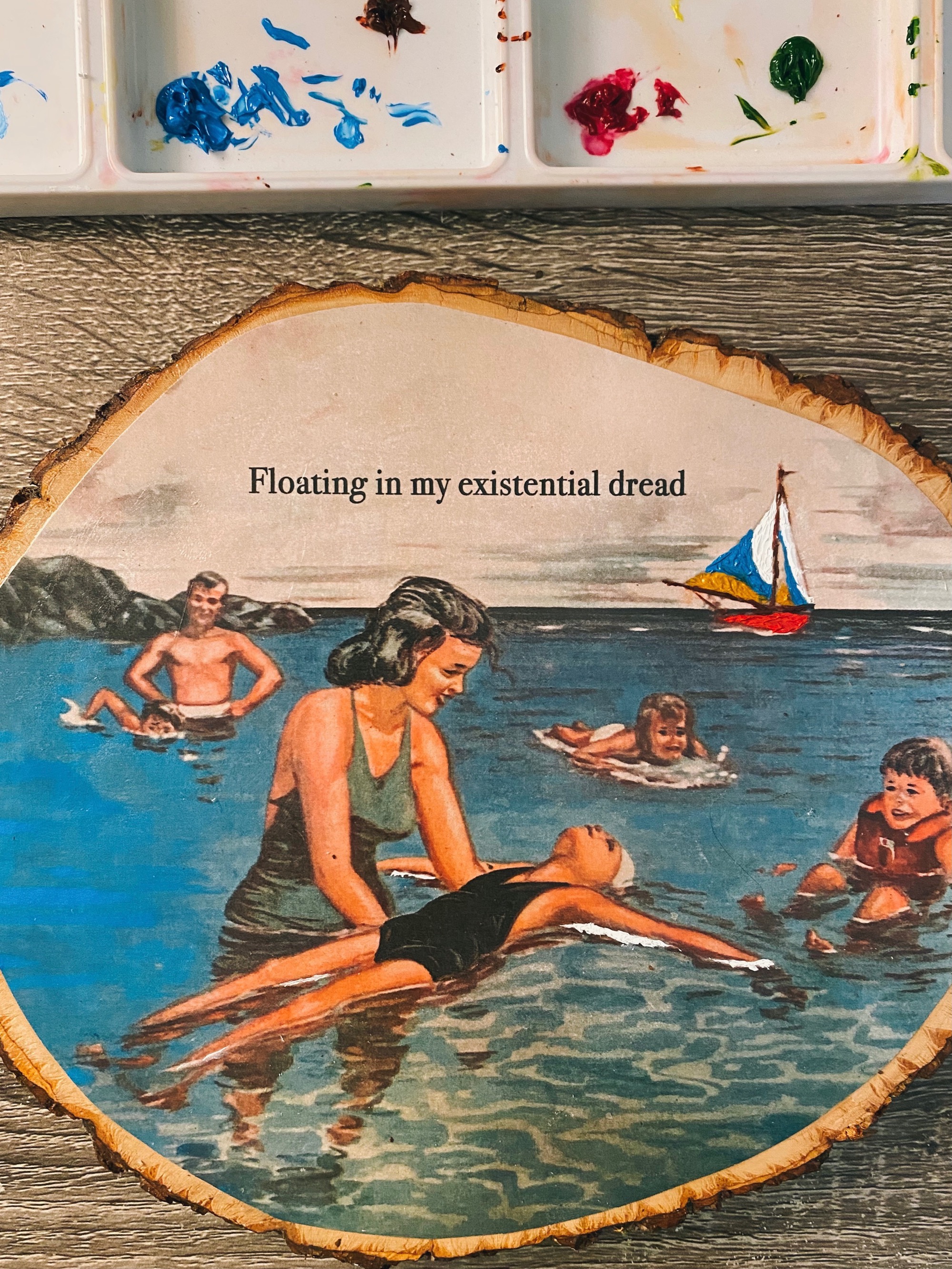 A photo of a woman holding a child floating in the water on a piece of wood