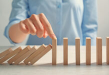 Mental Health Survival Kit, Chapter 5: Survival Kit for Young Psychiatrists in a Sick System (Part 5) Businesswoman hand trying to stop toppling dominoes on table