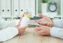Psychotherapy Has an Enduring Effect on Depression—in Contrast to Depression Pills closeup photo of two people's hands; one holding a pill bottle and one making a questioning gesture