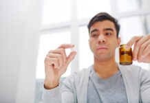 New Review: Antidepressants Come with Minimal Benefits, Several Risks guy holding pill