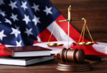 Malignant Do-Gooderism: The Tragedies of Allopathic Psychiatry Judge gavel with scales, books and american flag on wooden table
