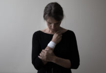 Why Do People Self-Harm, and How Can We Stop It? A photo of a woman holding her bandaged wrist