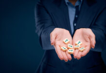 Critical Psychiatry Textbook, Chapter 7: Psychosis (Part Three) A photo of hands holding wood tokens printed with a key design