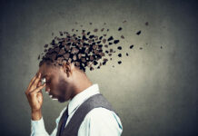 Chronic Stress and “Mental Illness” A Black man in a suit, in profile, with his head being fragmented digitally