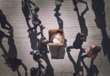 It’s Time for Soteria: An Australian Perspective A woman in a box is glowing while people walk around her