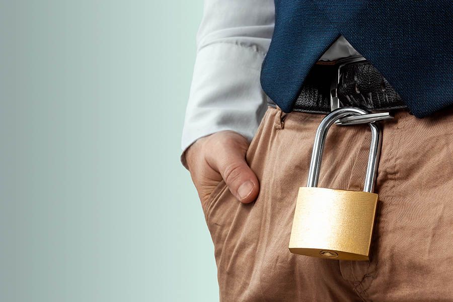 Close-up of a gold padlock hanging from a man's belt