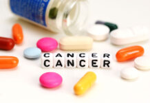 Cancer Risk Higher for Those on Clozapine Letter blocks spelling "CANCER" and spilled pills in various colors on a white background