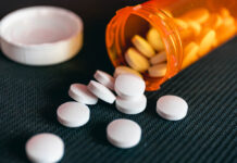 Critical Psychiatry Textbook, Chapter 8: Depression and Mania (Affective Disorders) (Part Eleven) Pills and orange pill bottle on black textured background