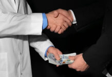 Critical Psychiatry Textbook, Chapter 8: Depression and Mania (Affective Disorders) (Part Thirteen) Closeup on hands. White male doctor and businessman shaking hands and passing a bribe with their other hands.