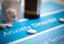 Critical Psychiatry Textbook, Chapter 10: Anxiety Disorders Closeup photo of pills on a sheet that reads "Anxiety Disorder"