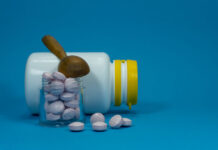 Critical Psychiatry Textbook, Chapter 15: Withdrawal of Psychiatric Drugs Pills spilling out of a white bottle on a blue background