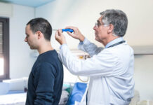 Critical Psychiatry Textbook, Chapter 16: Is There Any Future for Psychiatry? (Part Three) Stock photo of a white-coat male doctor holding a screwdriver to the head of a male patient as if to "fix" him.
