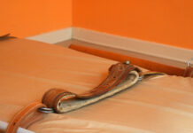 A Remarkable Feat: A Psychiatric Patient Changed the Law on Restraints Bed with restraints. Orange colored photograph