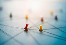 How the Psychosocial Approach Provides an Alternative to the Biomedical Model Macro photo of thumbtacks holding strings in a network on a blue background