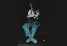 Dr. Gordon Warme: The Curious Case of an Unconventional Psychiatrist Dr. Gordon Warme, an older man, on a black background, with blue painted scribbles lighting up his legs