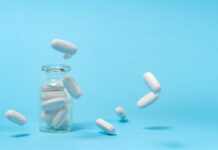 Much of U.S. Healthcare Is Broken: How to Fix It (Chapter 2, Part 1) White pills bounce out of clear bottle on blue background