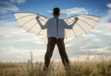Trying to Fly Above—An Example of Sequencity Boy with wings in the field in the afternoon against the blue sky