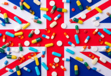 Beyond Pills: UK Parliament Must Support Social and Psychological Services Instead Plenty of capsules and pills laying on a flag of Great Britain. Concept of medicine and heath care in the UK.