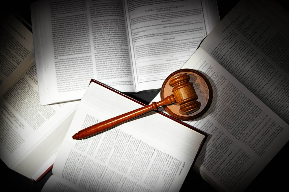 assorted open law books with legal gavel, in dramatic light