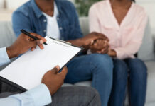 Never Waste a Good Depression: Family Therapy Challenges the Seductive Shortcut of Psychiatric Drugs Marital Counselor Taking Notes At Therapy Session With African American Spouses, Holding Blank Clipboard, Filling Information Form At Marriage Counseling Meeting With Blank Couple, Cropped Image