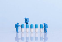 Much of U.S. Healthcare Is Broken: How to Fix It (Chapter 2, Part 8) Miniature photography. Blue and white pills and blue hazmat-suit figures