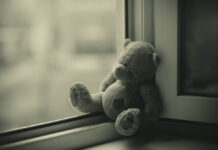 Medical Journals Refuse to Retract Fraudulent Trial Reports That Omitted Suicidal Events in Children A sepia-tone photograph of a lonely teddy bear small against a window.