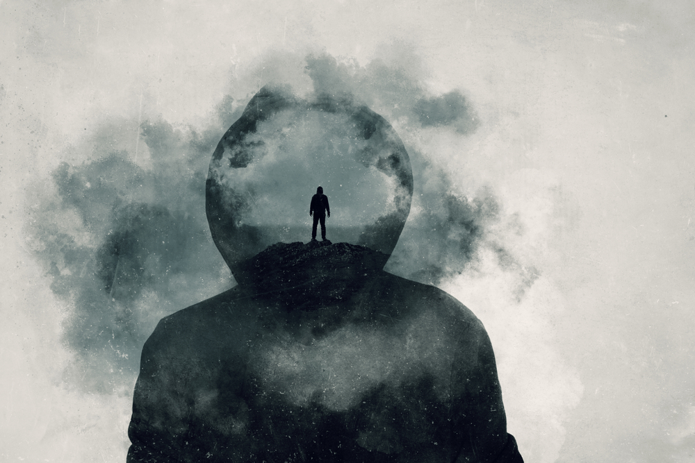A mental health concept. A mans head covered in clouds. With a double exposure of a mans silhouette over layered on top.