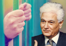 The Patient-Enemy: How Derrida Helps Explain Psychiatry’s Cruelty and Care Stock photo of hands on the bars of a cell, collaged with Derrida's face over the right side