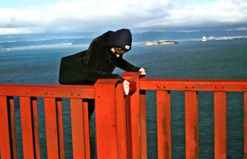 person climbing over the railing on Golden Gate Bridge