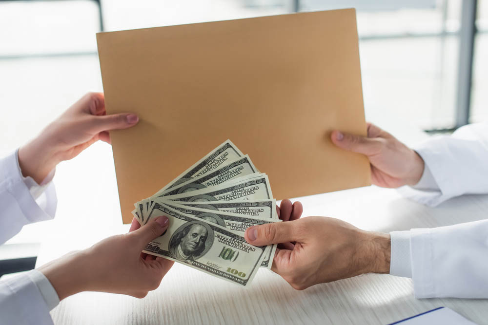 Doctors exchange money and an envelope