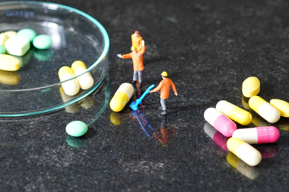 Miniature people - The worker at work with medicine pills