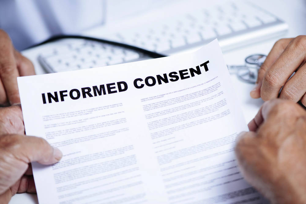 Close up of document titled "Informed Consent" being held