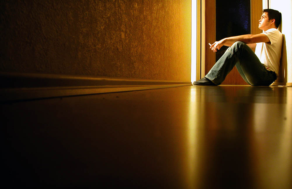Person sitting in the distance, yellow light corridor