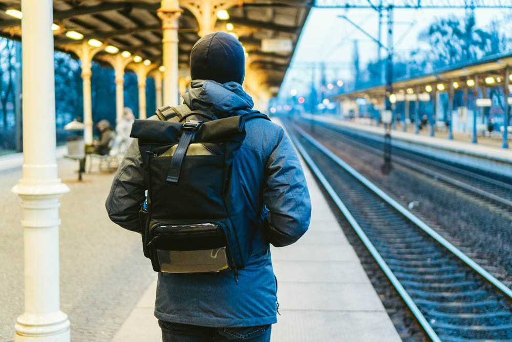 Train Station in Sopot, Poland, Europe. Attractive man waiting at the train station. Thinking about trip, with backpack. Travel photography. tourist with backpack stand on railway station platform.
