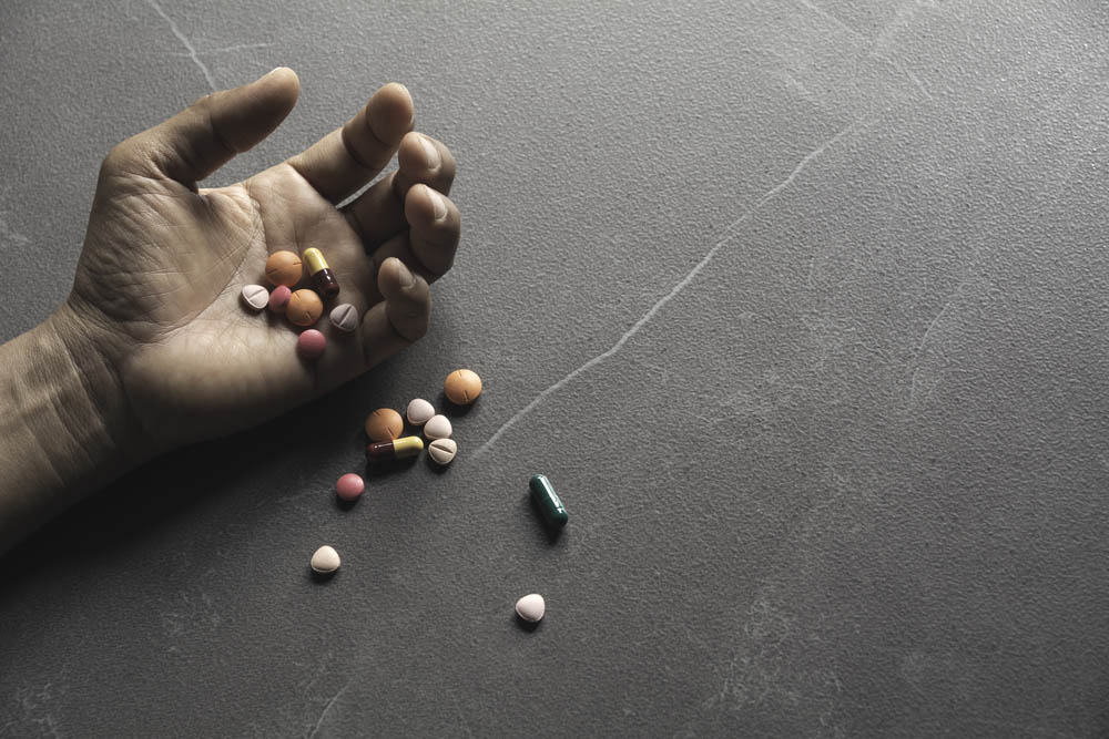 Pills spilling out of an outstretched hand