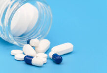 Animal Study: SSRI Neurotoxic in Pregnancy Close up of Pills spilling out of pill bottle on blue background. with copy space. Medicine concept .