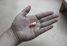 What I Have Learned in Working With 300+ People in Their Journey of Tapering Black and white photo of a hand holding a colorized pill