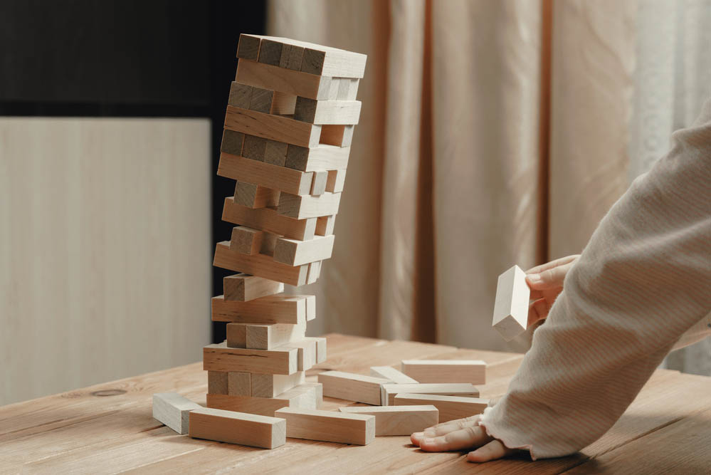 A jenga tower of bricks begins to collapse