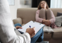 The Moral World of Personality Disorder Assessment Professional psychotherapist and patient in office, focus on hands with clipboard
