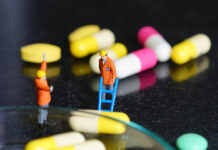 Antidepressant Trials Last Eight Weeks, So Why Do We Take Them for Years? Miniature people - The worker at work with medicine pills
