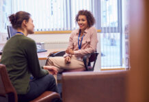 Therapists, Neutrality Is No Longer an Option — Politics Is Tearing Us Apart Female College Student Meeting With Campus Counselor Discussing Mental Health Issues