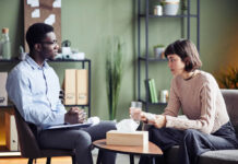 Between Diagnoses and Dialogue: The Silent Conflict Between Psychiatry and Psychology Black male therapist listening to White female client