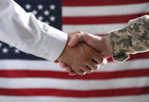 Veteran Suicide Prevention Legislation Introduced That Will Save Lives Soldier and politician shaking hands against flag of USA, closeup