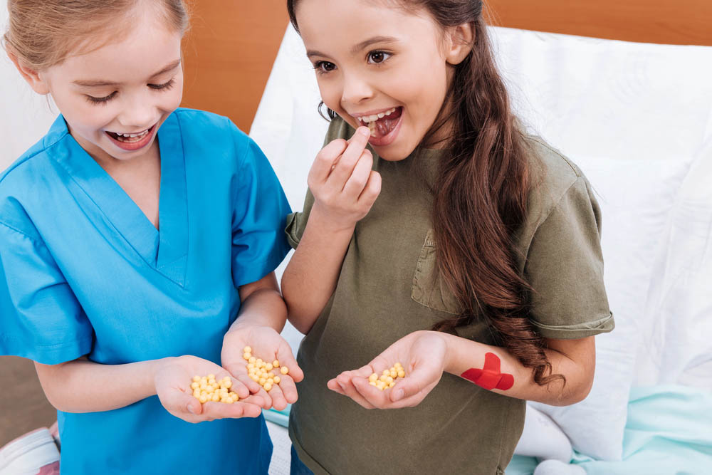 A couple of kids chowing down on some little pills