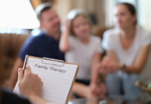 When the Family Is the Patient Close-up of psychologist at psychotherapy session with family in office. Psychology and family therapy concept