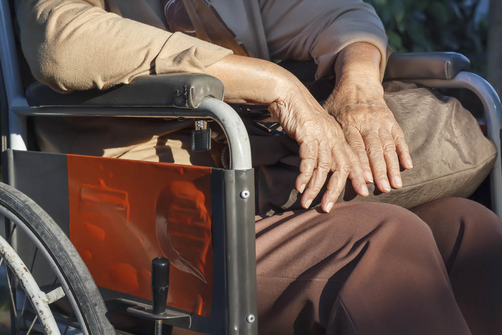 older adult hands close-up, wheelchair